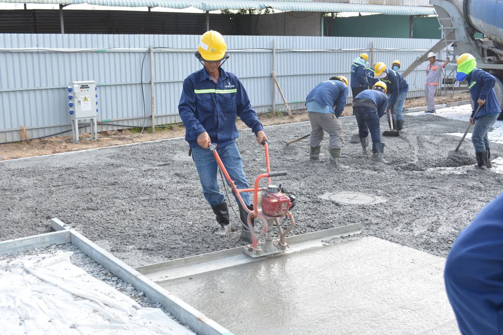 Concept photograph. A crew smoothing wet concrete.