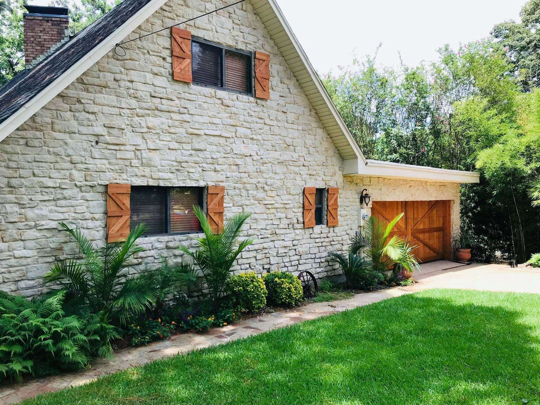 A wood garage door on a stone house.