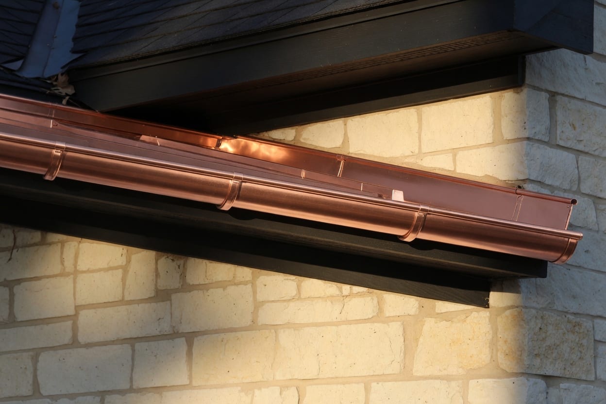Concept photograph of a copper gutter run, used on the Absolute Seamless coil desk mockup.